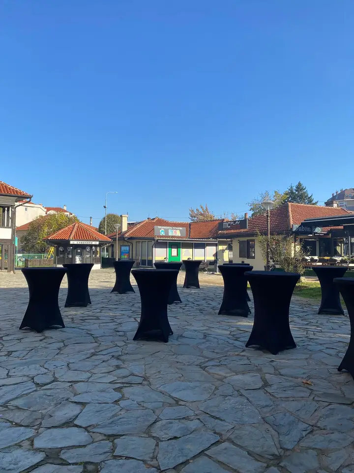 Barski stolovi sa crnim navlakama na kamenom platou