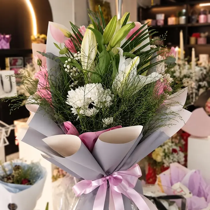 Buket belih ljiljana i belog cveća u sivom i roze papiru