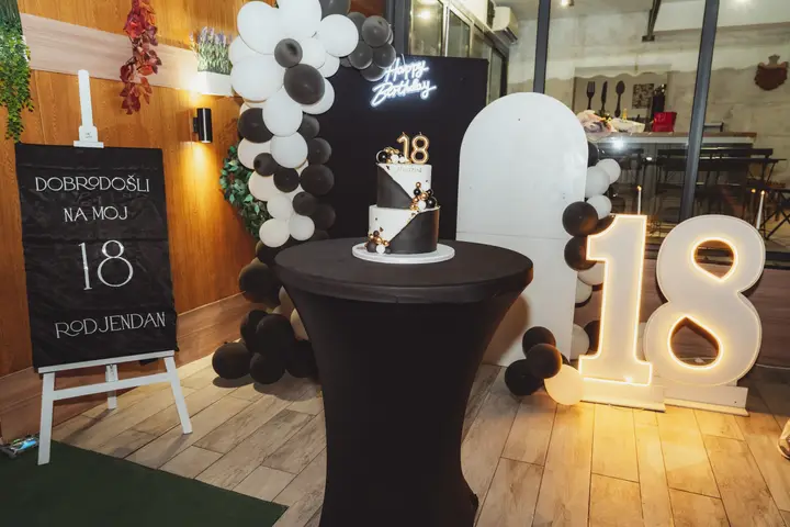 Torta na barskom stolu i svetleće brojke 18 za rođendan